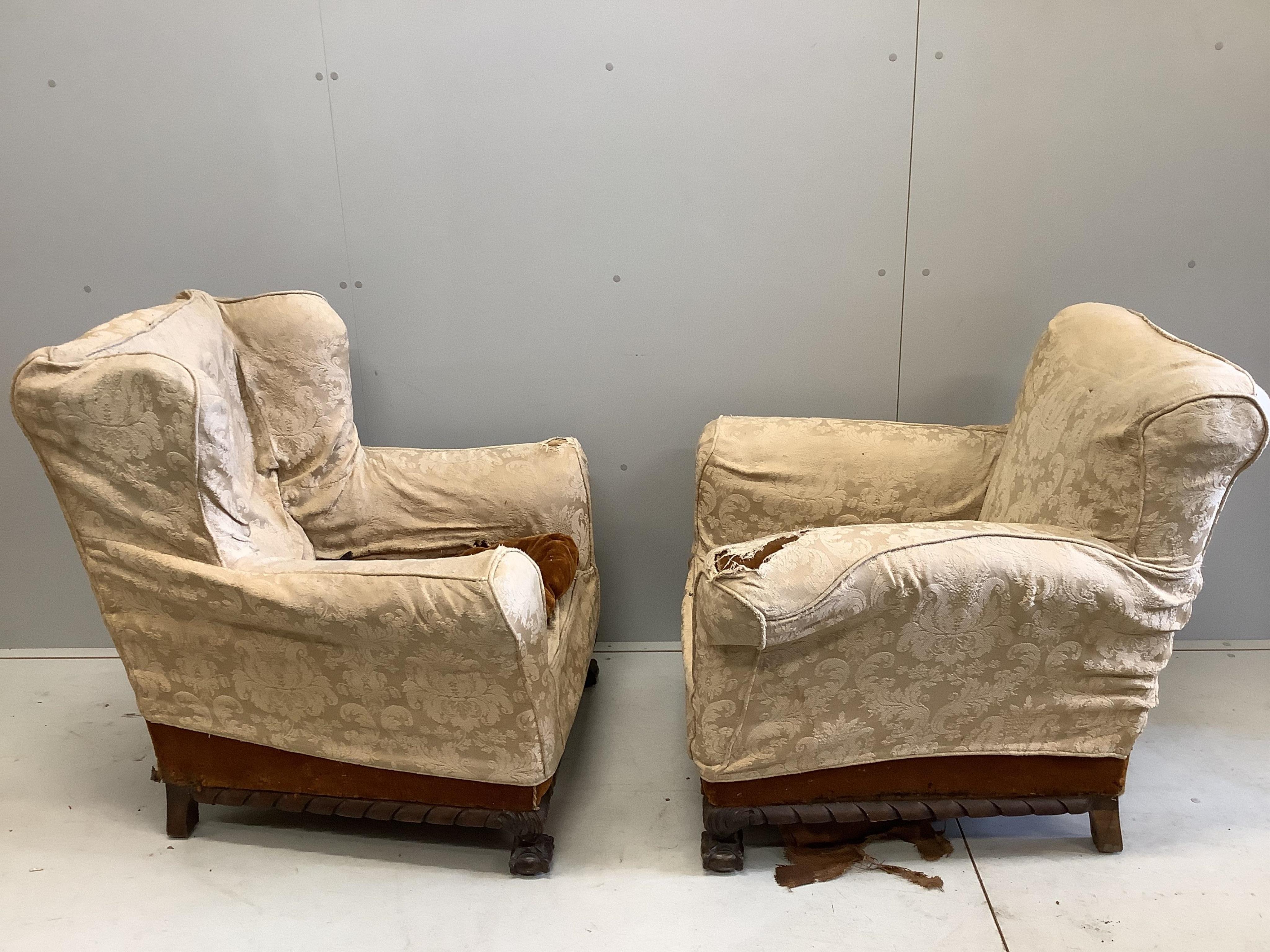 A near pair of early 20th century upholstered armchairs, larger width 81cm, depth 78cm, height 88cm. Condition - poor